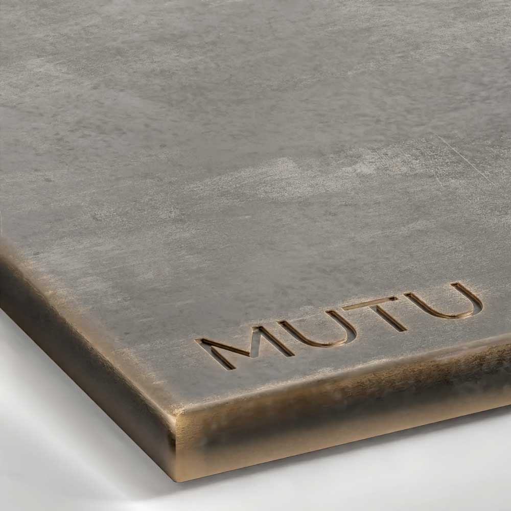 A close-up view of a Patina Bronze metal surface, showcasing a dark, warm brownish-bronze tone with subtle variations in color and a soft, hand-rubbed satin sheen.