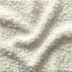 Close-up swatch of heavy-textured Bouclé fabric in a bright, crisp Snow White color, showing the intricate knotted loops and three-dimensional woven surface.