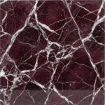 A detailed view of a polished Rosso Levanto marble surface, featuring a deep, blood-red to burgundy background intricately laced with chaotic, hairline veins of bright white.