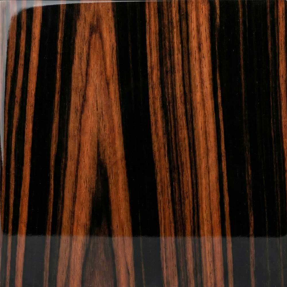 A close-up of a polished Macassar Ebony veneer, featuring a dramatic high-contrast pattern of deep black stripes running through a rich reddish-brown background.