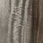 A macro shot of a Smoked Eucalyptus veneer, revealing a deep chocolate-brown to charcoal tone with a shimmering, rippled grain texture that catches the light.