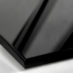 A close-up of a Polished Black Lacquer surface, featuring an opaque, jet-black finish with a flawless, high-gloss mirror reflection.