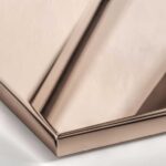 A close-up view of a Polished Rose Gold metal surface, characterized by a bright, reflective mirror finish with distinct pink and copper hues.