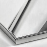 A close-up of a Polished Stainless Steel surface, featuring a bright, cool silver tone with a perfect, mirror-like reflectivity.